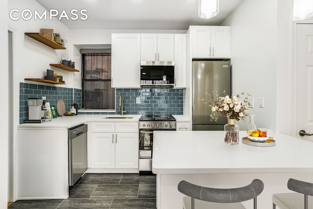 kitchen with stainless steel appliances, open shelves, a kitchen breakfast bar, and a sink