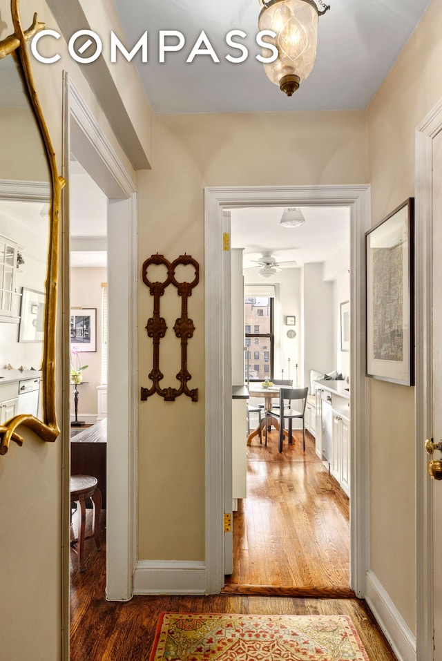 hallway with baseboards and wood finished floors