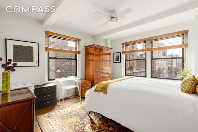 bedroom with beamed ceiling, a ceiling fan, and light wood finished floors