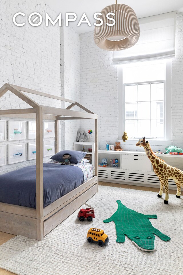 bedroom featuring brick wall and a high ceiling