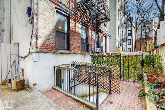 view of home's exterior featuring brick siding, stucco siding, and fence