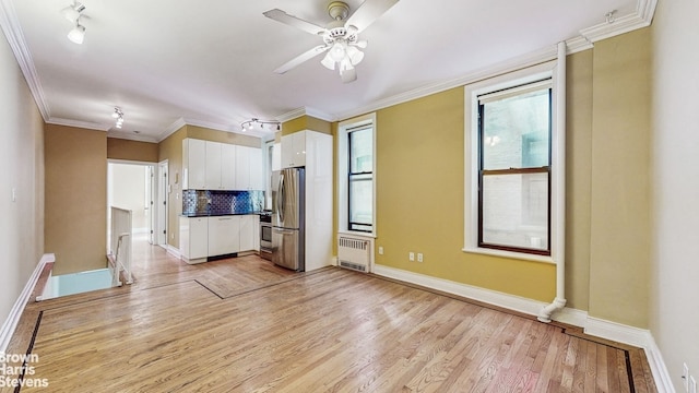 unfurnished living room with crown molding, radiator, baseboards, light wood-type flooring, and a ceiling fan