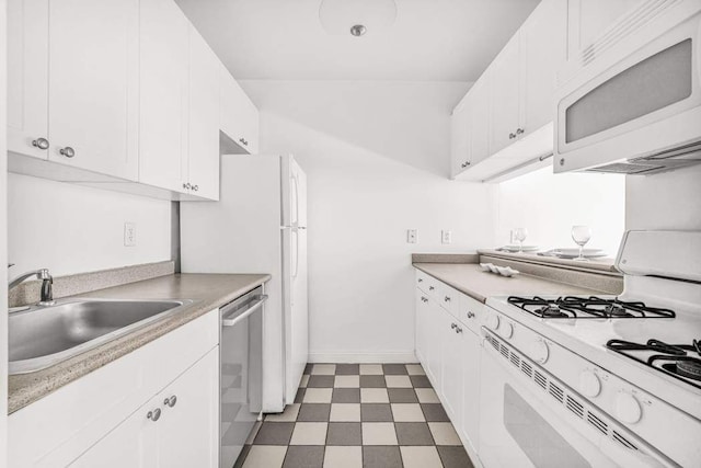 kitchen featuring white appliances, a sink, white cabinets, light countertops, and light floors