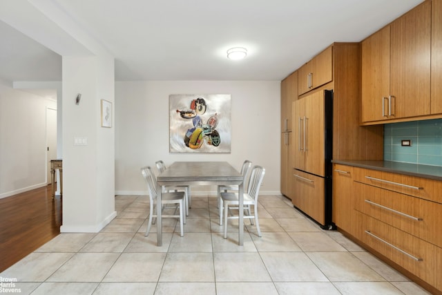 dining space with light tile patterned floors and baseboards