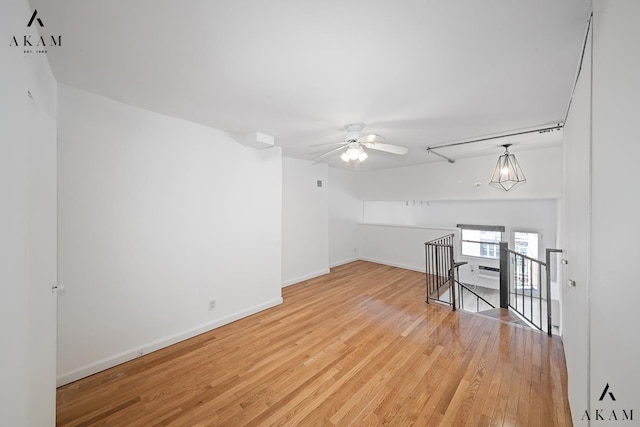 empty room featuring a ceiling fan, light wood-style flooring, and baseboards