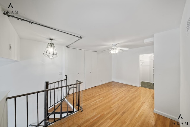 spare room with light wood-style floors, ceiling fan, and baseboards