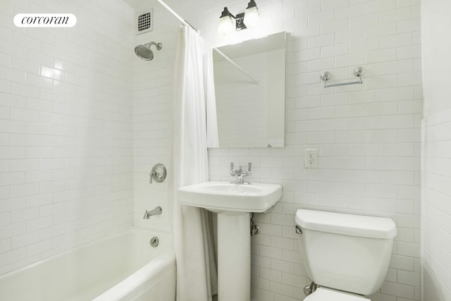 full bath with tile walls, visible vents, shower / bathtub combination with curtain, toilet, and a sink