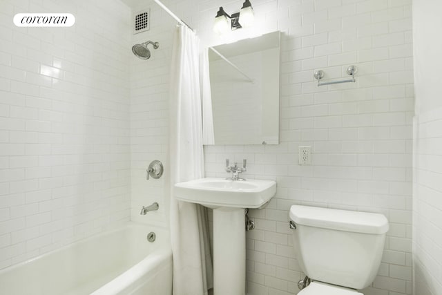 225 E 36th St Unit 2B, New York City, NY 10016 - bathroom featuring tile walls, shower / bath combination with curtain, toilet, and a sink
