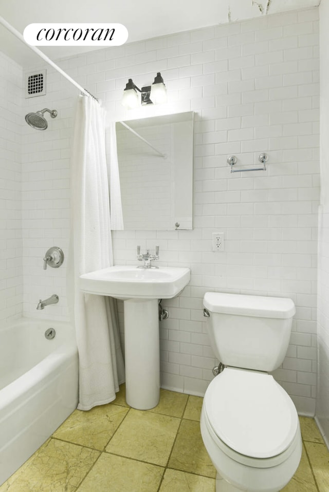 full bath with toilet, visible vents, tile walls, tile patterned floors, and shower / tub combo with curtain