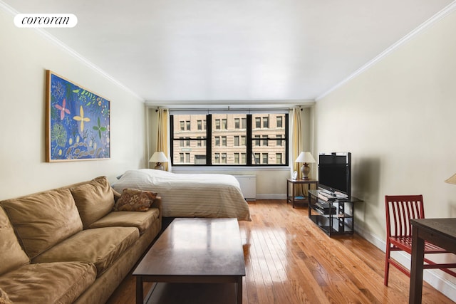 bedroom with hardwood / wood-style floors, baseboards, visible vents, and crown molding