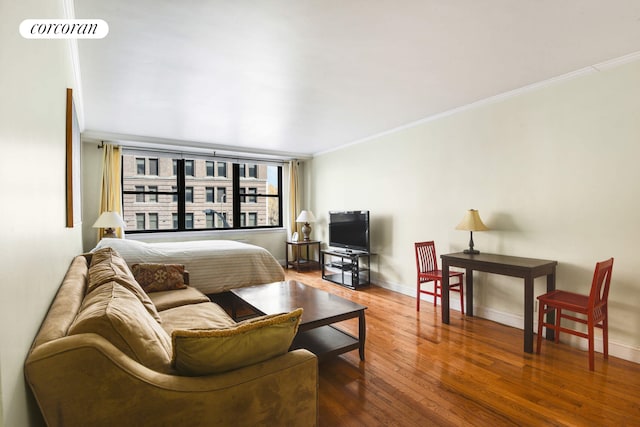 living room with ornamental molding, baseboards, and wood finished floors