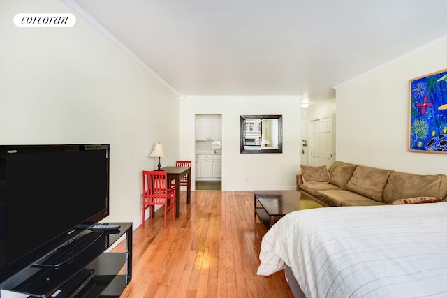 bedroom featuring ornamental molding, visible vents, light wood-style flooring, and baseboards