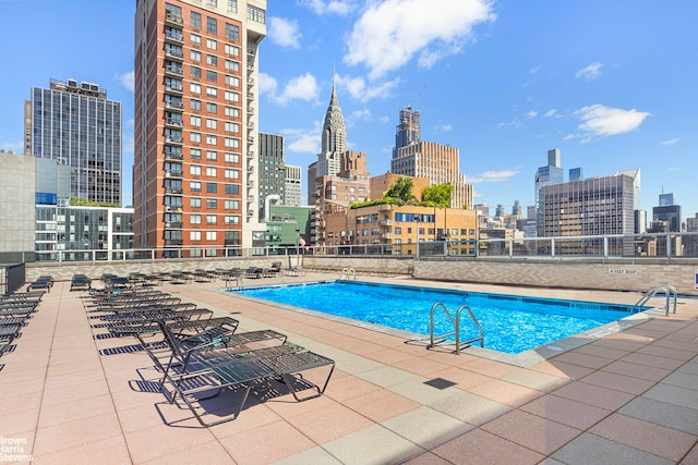 pool featuring fence, a city view, and a patio