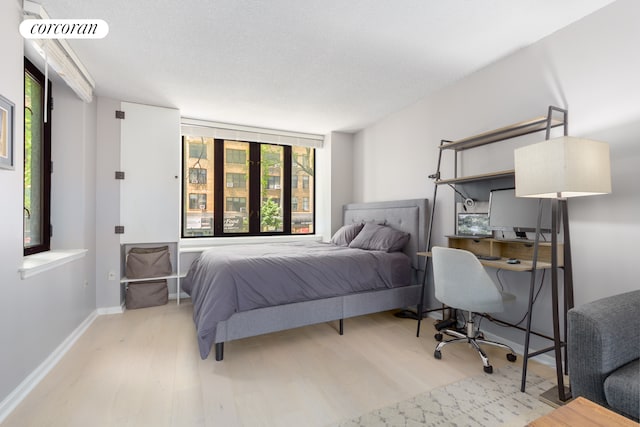 bedroom with visible vents, baseboards, and wood finished floors