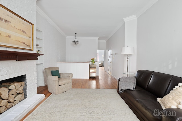 living area featuring crown molding, a fireplace, built in features, and wood finished floors