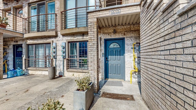 view of exterior entry with a balcony