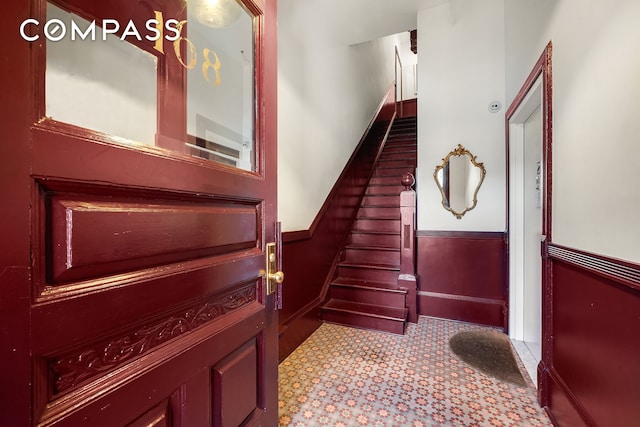 stairway featuring a wainscoted wall