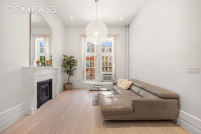 living room with recessed lighting, a fireplace, wood finished floors, and radiator