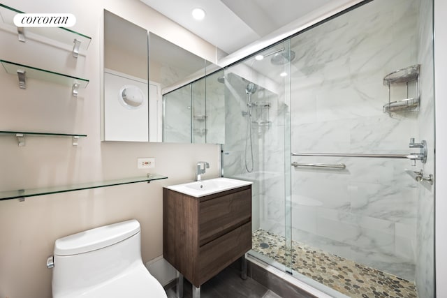 bathroom featuring a marble finish shower, vanity, and toilet