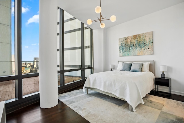 bedroom featuring floor to ceiling windows, a notable chandelier, baseboards, and wood finished floors