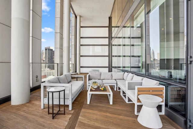 living room with a wall of windows and wood finished floors