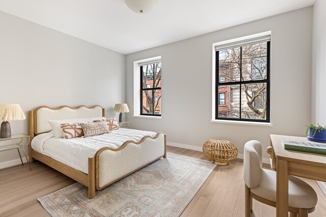 bedroom featuring baseboards and light wood finished floors