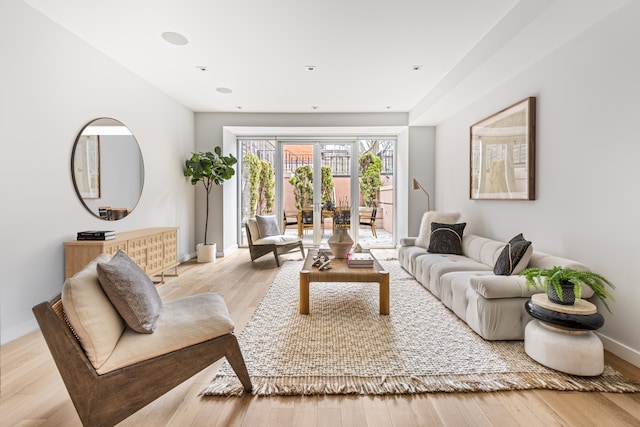 living area featuring french doors, baseboards, and wood finished floors