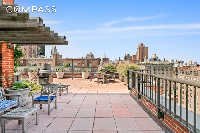 view of patio featuring a view of city, outdoor dining area, and a balcony