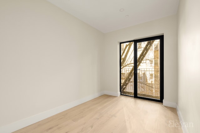 unfurnished room featuring baseboards and light wood-type flooring