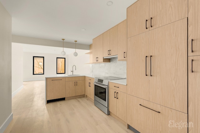 kitchen with stainless steel electric range oven, light brown cabinets, a peninsula, a sink, and light wood-style floors