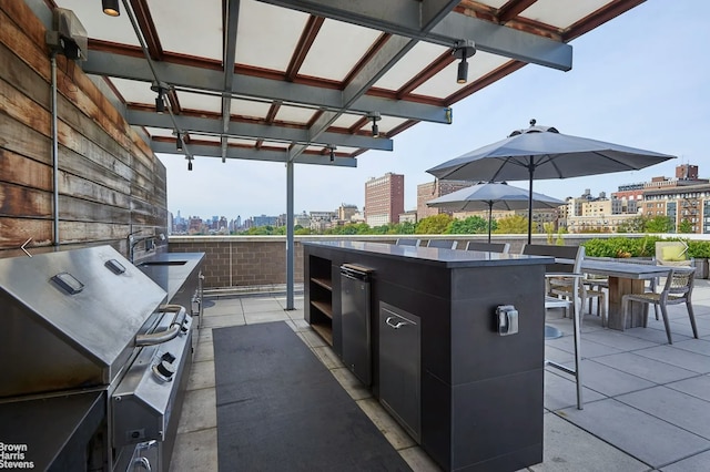 view of patio with outdoor dining area, grilling area, and a city view