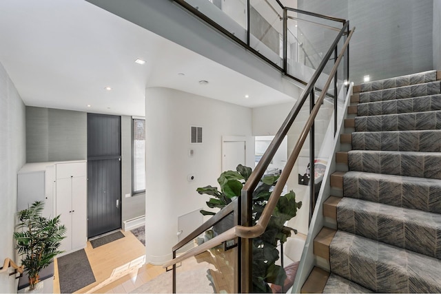 stairway with visible vents and wood finished floors