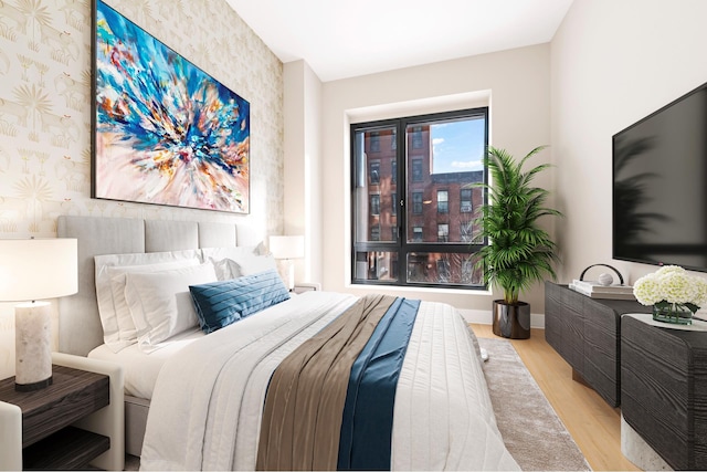 bedroom featuring baseboards, wood finished floors, and wallpapered walls