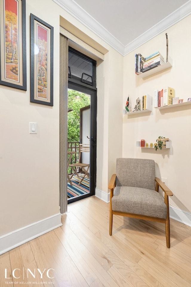 sitting room featuring crown molding, wood finished floors, and baseboards