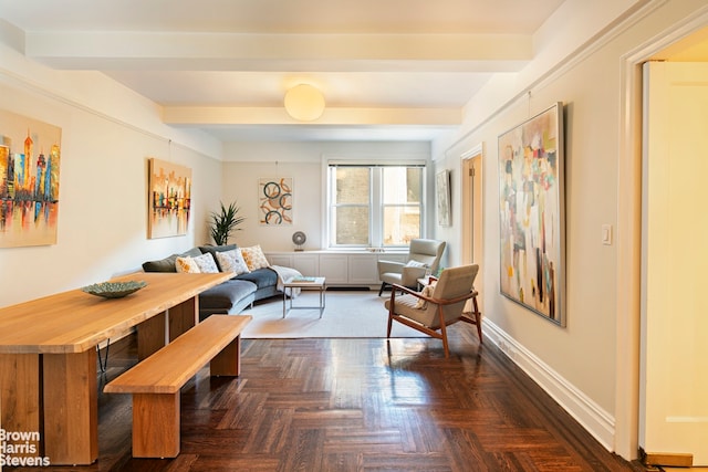 living area featuring beamed ceiling and baseboards