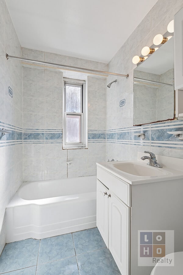 full bath with bathtub / shower combination, tile walls, vanity, and tile patterned floors