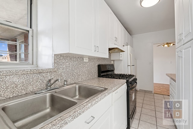 kitchen with white appliances, a sink, white cabinets, light countertops, and backsplash