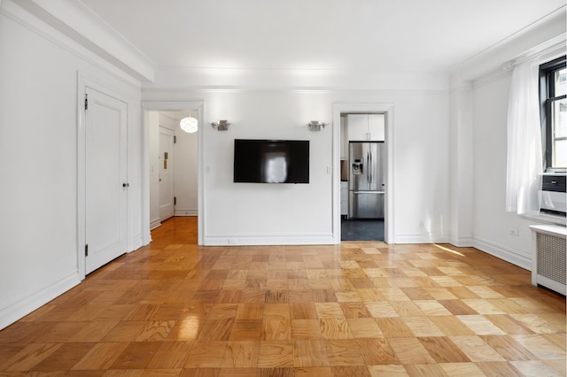 unfurnished living room featuring radiator heating unit and baseboards