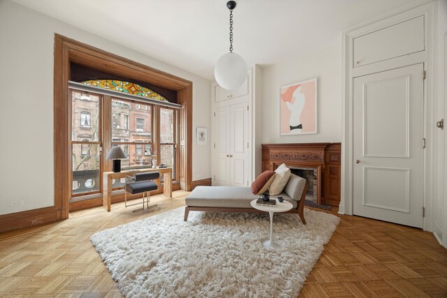 sitting room with a fireplace and baseboards