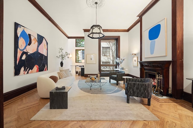 sitting room with baseboards, ornamental molding, and a warm lit fireplace