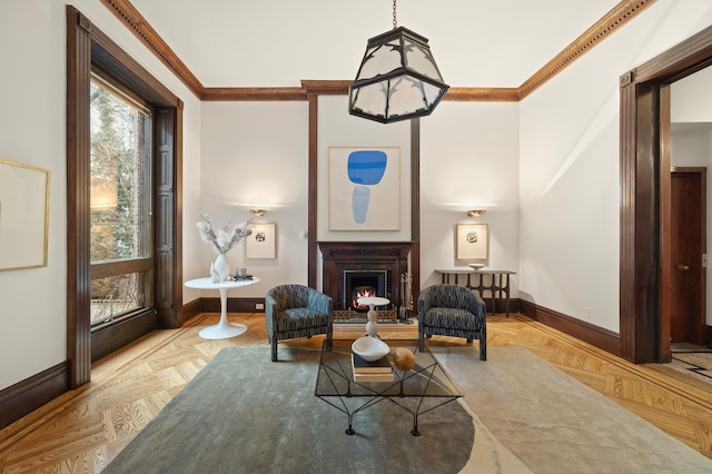 living area featuring baseboards, a warm lit fireplace, and ornamental molding