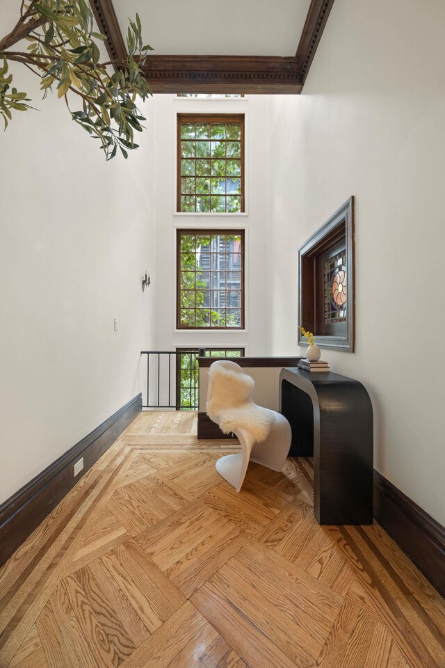 sitting room with a high ceiling and baseboards