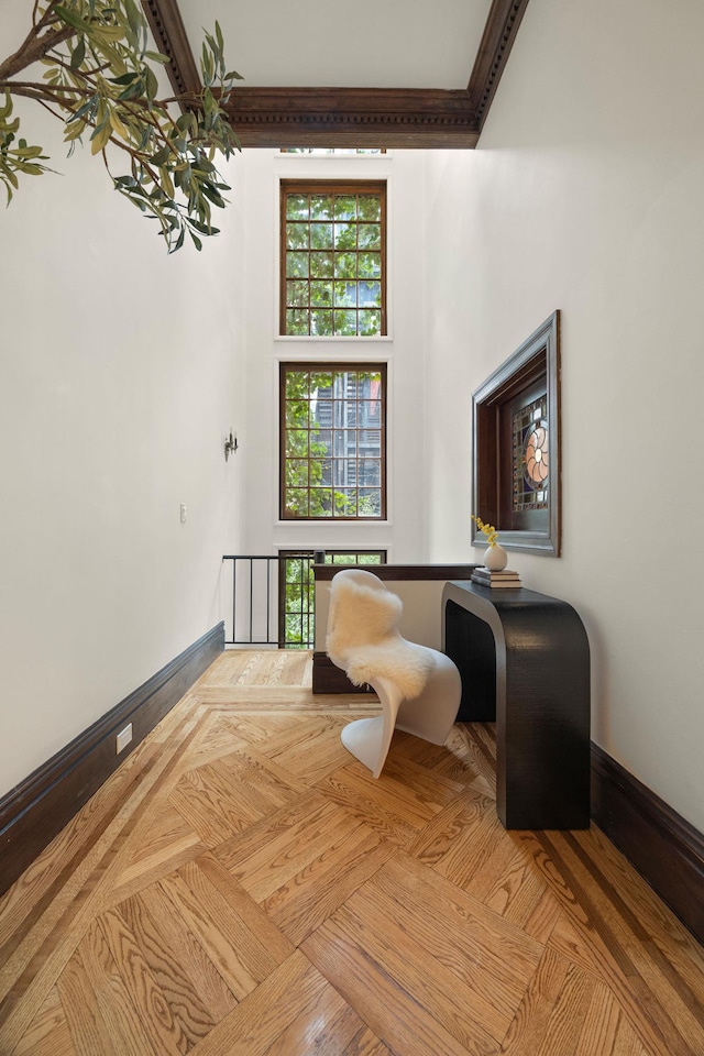 living area featuring crown molding and baseboards