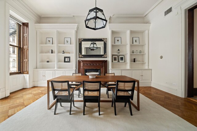 dining space with visible vents, baseboards, crown molding, and built in shelves