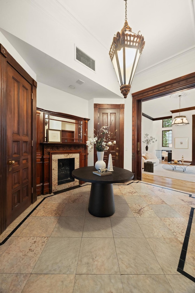 interior space featuring ornamental molding, a premium fireplace, and visible vents