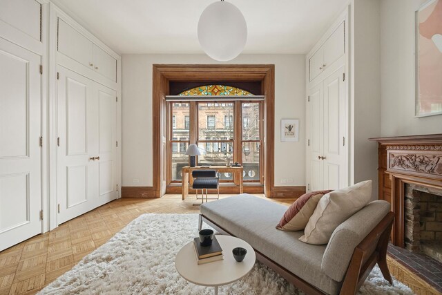 sitting room featuring a high end fireplace and baseboards