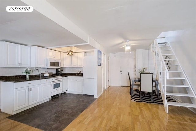 kitchen with dark wood-style floors, visible vents, a ceiling fan, white cabinets, and white appliances