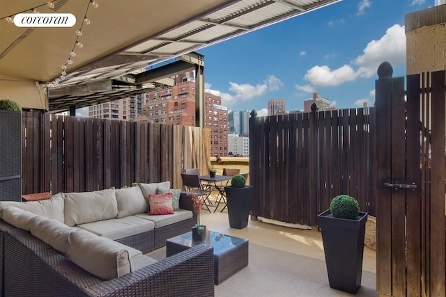 view of patio / terrace featuring a view of city, visible vents, fence, and an outdoor hangout area