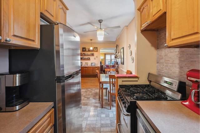 kitchen featuring decorative backsplash, appliances with stainless steel finishes, and a ceiling fan