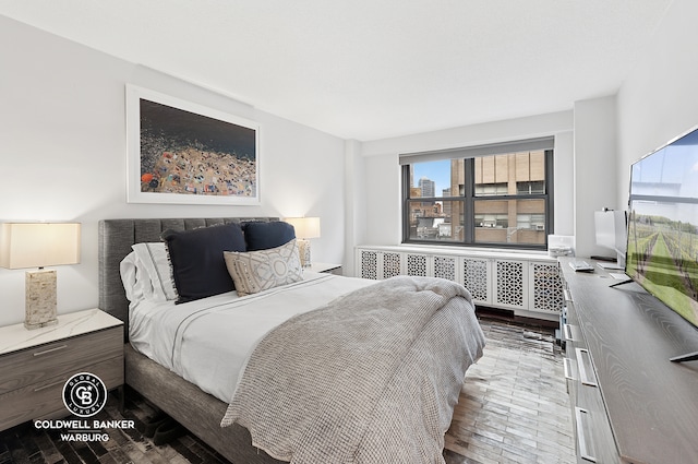 bedroom with radiator and wood finished floors